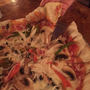 pizza vegetariana con borde de pepperoni, mozzarella y aceitunas