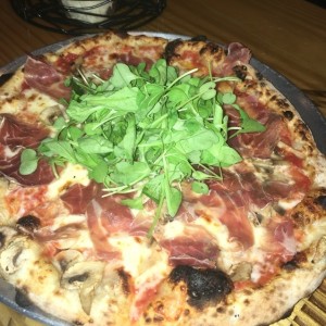 pizza de prosciuto, arugula y hongos