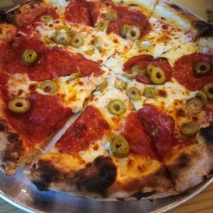 pizza de peperoni con aceitunas verdes.