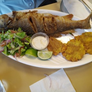 Corvina entera apanada con patacones y ensalada verde.
