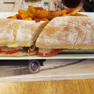 Emparedado de pollo con ensalada cesar y papas