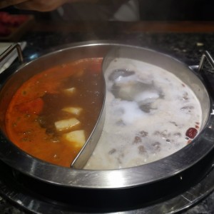 hot pot grande; caldo de tomate (derecha) y caldo de coco y ciruela (izquierda)