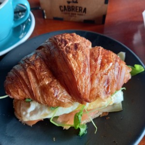croissant gordito de salmon, aguacate, queso gouda, huevo y rugula. exquisito