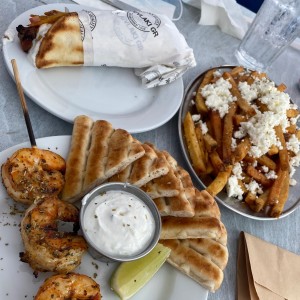 souvlaki de tzatziki y cerdo, papas griegas y brocheta de la gostinos