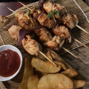 Brochetas de pollo con papas wedge.