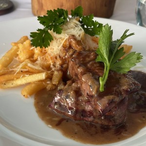 Filete a la pimienta con papas fritas con prmesano y toque de trufa