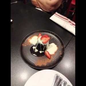 Volcán de chocolate hecho de esponjoso bizcocho relleno de chocolate fundido y acompañado de un quenelle de helado de vainilla