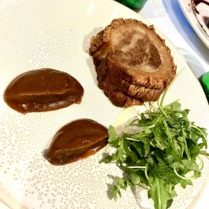 Chef?s special Porchetta with a date sauce on the side and fresh arugula salad