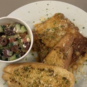 Lasaña de carne con tostadas y ensalada griega