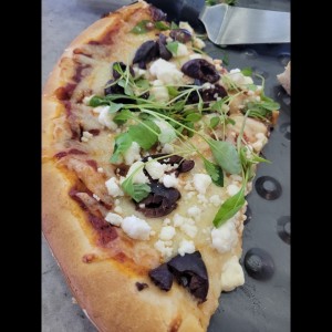 pizza con feta, Kalamata y rugula.