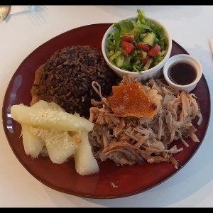 Lechón, arroz congrio, yuca al mojo y ensalada.