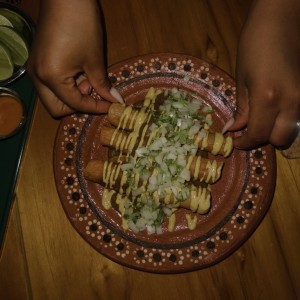 Flauta de pollo ahogada en salsa de tamal 