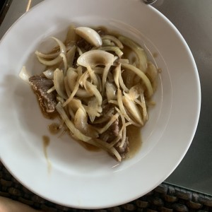 Bistec de carne encebollado
