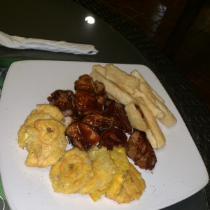Entrada con costillitas de puerco a la BBQ con patacones y yuca.