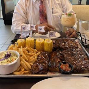 Costillas, papas, mazorcas, ensalada de col