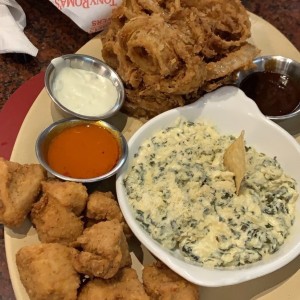 aros de cebolla, chicken bites y dip de espinaca con nachos coloridos de entrada