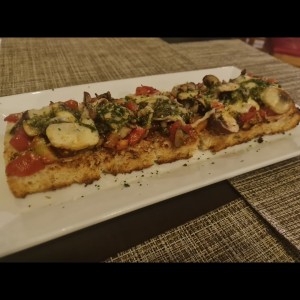 bruschetta al pesto hongos tomate y mozzarella