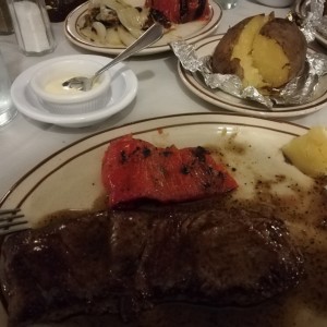 filete a la pimienta, papas asadas y vegetales a la brasa