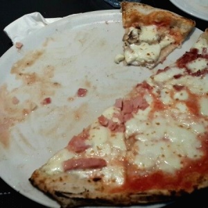 Pizza Cuatro Estaciones (muy mala) el queso soltaba agua (ver a un lado del plato) - hizo que toda la masa estuviese aguada)