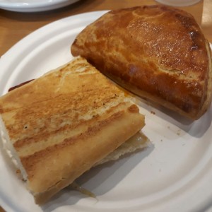emparedado de cantimpalo y provolone y empanada de espinaca y queso