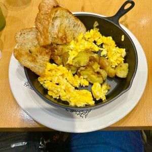 Papa Spicy (Papines, huevos revueltos, salsa picante y tostadas de pan de masa madre.)