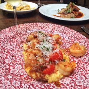 Langostinos Asados sobre polenta con cebolla caramelizada y tomate cherry