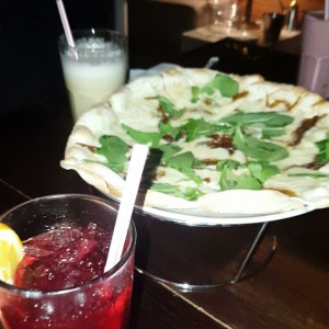 Pizza tres quesos con cebolla caramelizada y rugula