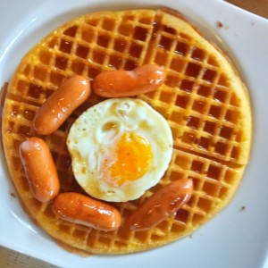 waffles con salchichas, huevos y syrup