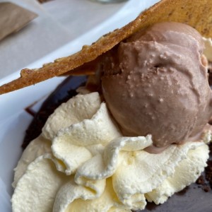 Heldado de chocolate, chantilly y cama de cacao