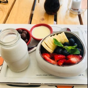 Plato de frutas, leche de almendras, bolitas de chocolate y leche condensada