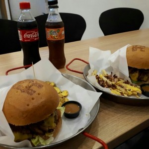Hamburguesas rusticas acompañas de papas criollas y papas a la francesa con queso cheddar y bacon. 