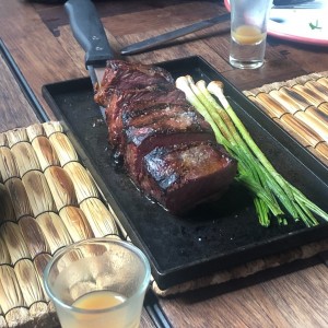 new york steak. con chicha ligera y cebollines asados.