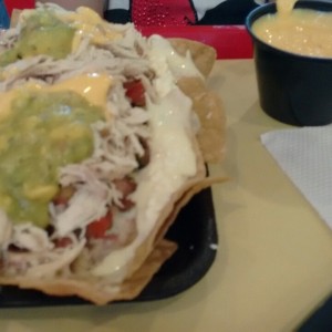 Nachos de pollo y salsa de queso cheddar