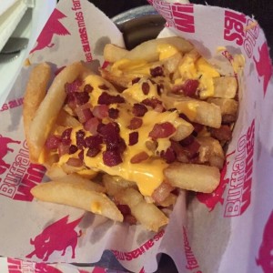 Papas fritas Madona con extra de queso fundido y tocineta