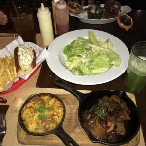 perro caliente de langosta, ensalada cesar y solomo salteado con cebollas