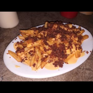 Papas con queso fundido y tocineta