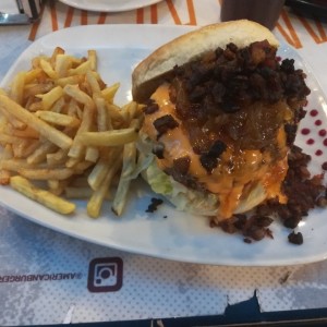 Vegas Burger. Doble carne, cebolla caramelizada, abundante tocineta y queso fundido (más bien una salsa de queso). Buena porción de papas fritas, y la tradicional ensalada coleslaw la sustituyeron por una César que estuvo excelente.