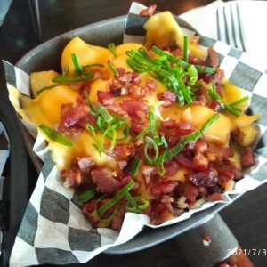 Papas Bravas con cheddar y tocineta