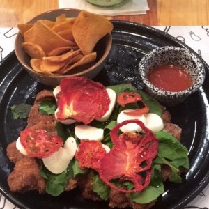La Mozza Milanesa (milanesa con topping de mozzarella, rugula, boconccini y tomates secos)