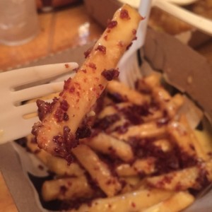 Papas fritas con queso fundido y tocineta