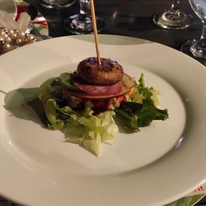 hamburguesa de pescado con tocineta ,champiñón, manzana verde en cama de lechugas. 