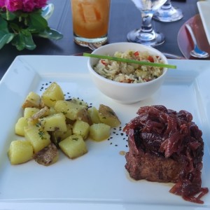 lomito con cebolla caramelizada en reducción de vino tinto con papas en finas hierbas y arroz salteado. 