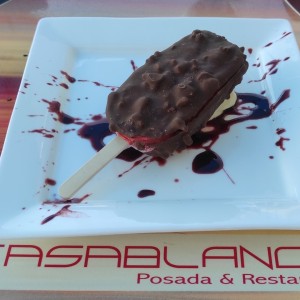 Butter cream con queso crema y reducción de mora con paleta de mora con cobertura de chocolate. 