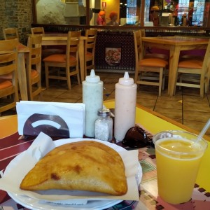 Empanada de carne Mechada y queso con jugo de naranja 