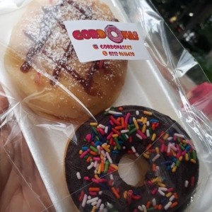 dona rellena de arequipe y la otra con chocolate y lluvia de colores