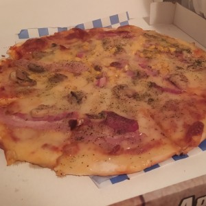 Pizza con tocineta, maíz y champiñones.