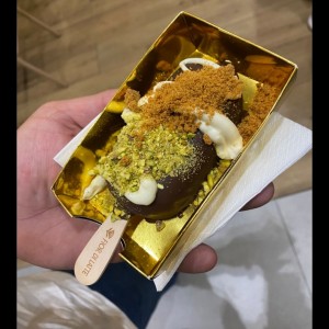 paleta helada de fresa con capa de chocolate, lottus y pistacho 