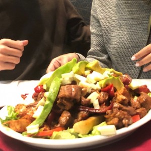 Parrilla con pollo, carne, yuca frita (poca), aguacate, cubitos de queso, vegetales y salchicha