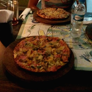 Al fondo, pizza a la crema de ajo porro y tocinet, al frente la diavolessa