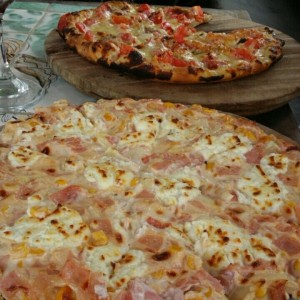 Pizza a la crema (queso de cabra con tocineta y maiz) y pizza con anchoas